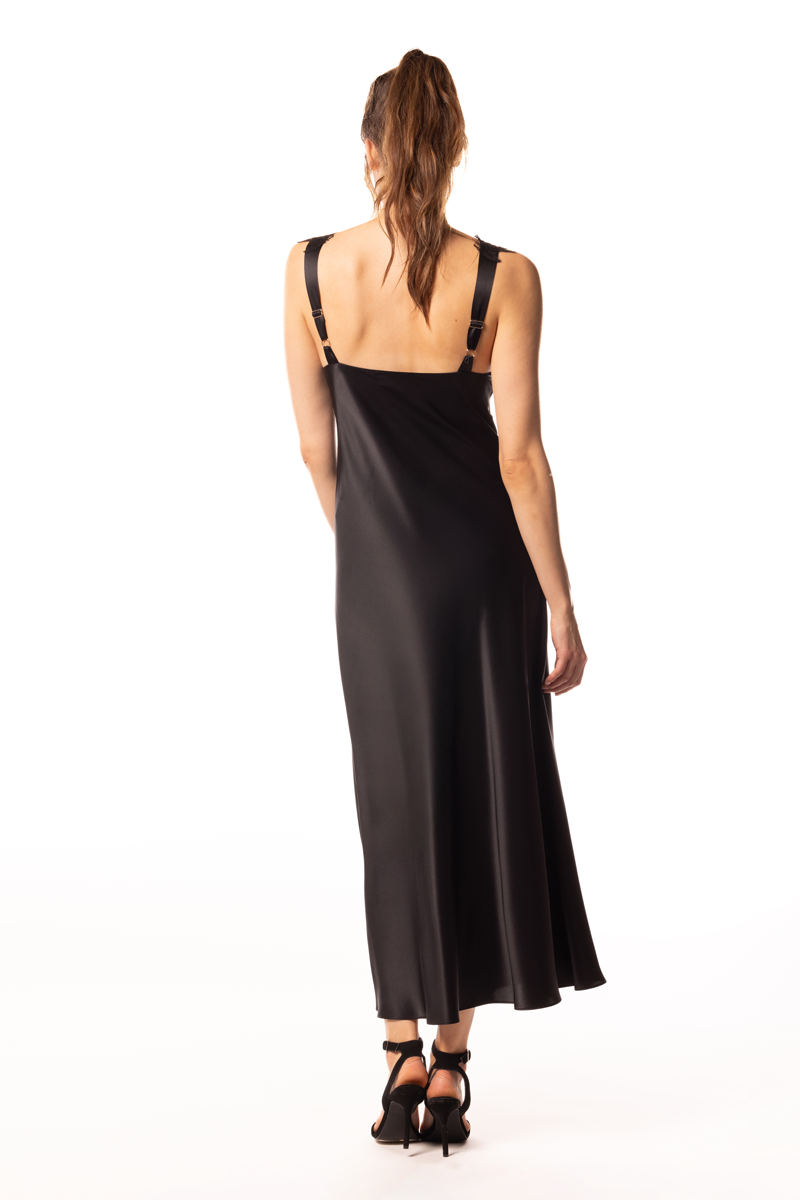 Woman wearing a black slip dress on a white background