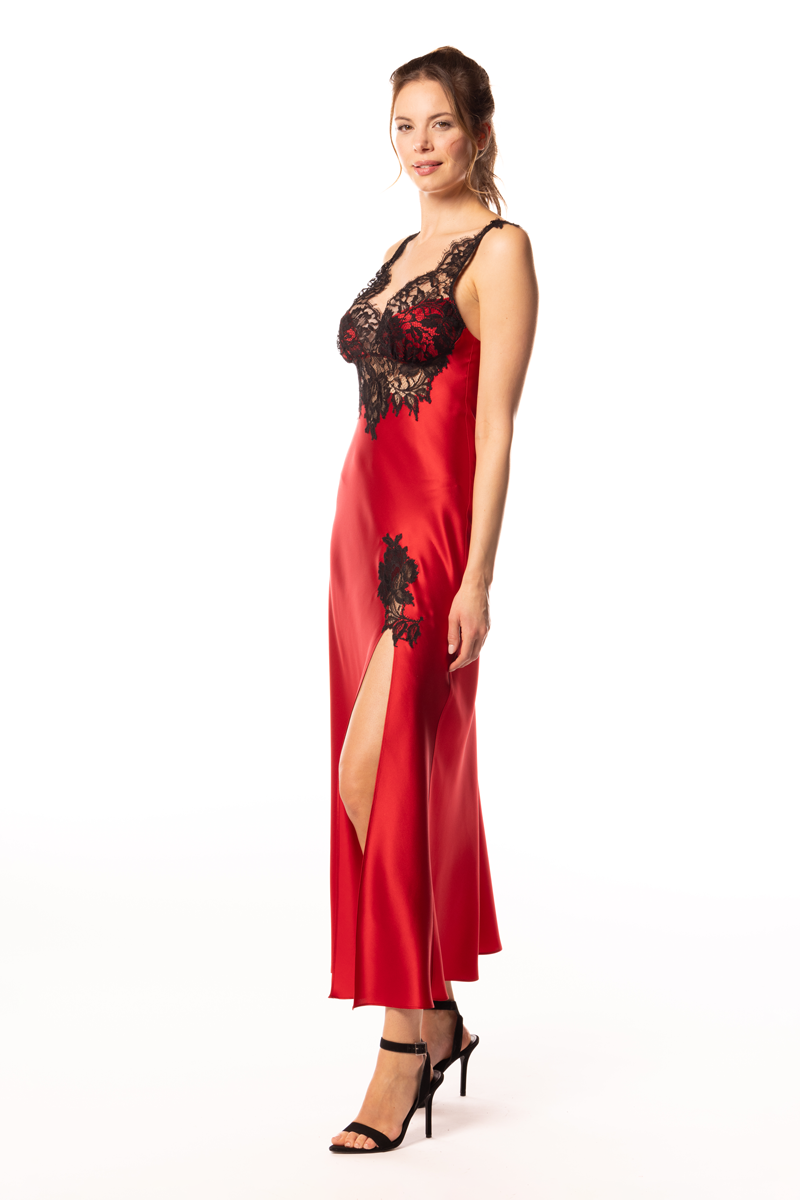 Woman wearing a red satin nightgown with black lace details on a white background